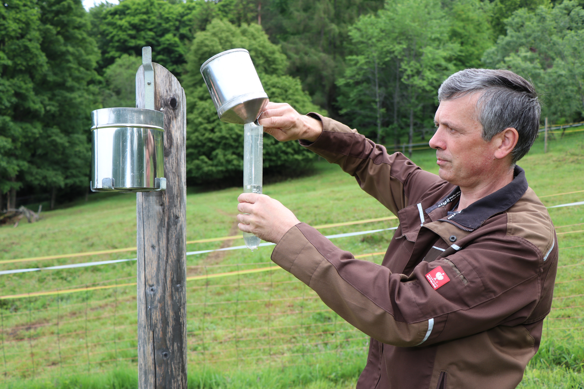 Ludwig Höcker misst in der Klimastation Waldhäuser die Niederschlagsmenge eines Tages. Daneben werden dort seit 1970 auch Temperaturen, Windgeschwindigkeiten oder Schneedichten erfasst.  (Foto: Gregor Wolf/Nationalpark Bayerischer Wald) 